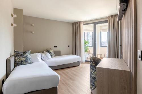 a hotel room with two beds and a table at Acta Pirámides in Madrid
