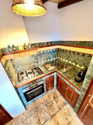 a kitchen with a stove and a sink at Chalet Del Bosco - Piccola Svizzera in Tagliacozzo