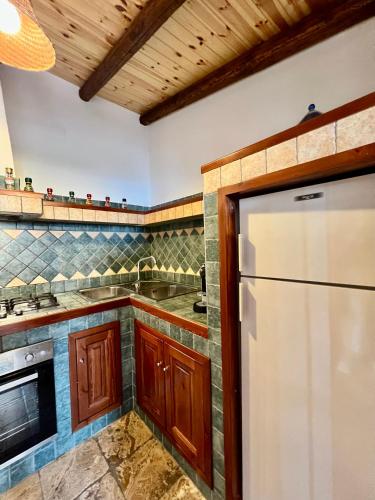 a kitchen with a white refrigerator and wooden cabinets at Chalet Del Bosco - Piccola Svizzera in Tagliacozzo