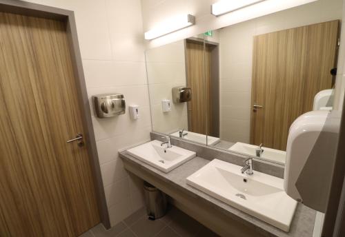 a bathroom with two sinks and a large mirror at Budafoki Sporthotel in Budapest