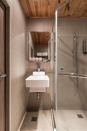 a bathroom with a sink and a shower at The Riverside Hotel Hengchun in Hengchun
