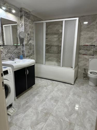 Un baño con lavabo y lavadora. en Bursa central house, en Bursa