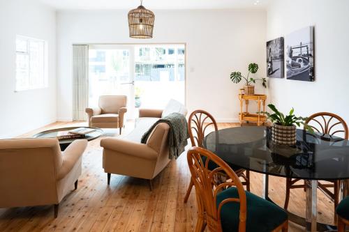 a living room with a table and chairs at Casa Caprice - a 3 bed home steps from the beach in Cape Town