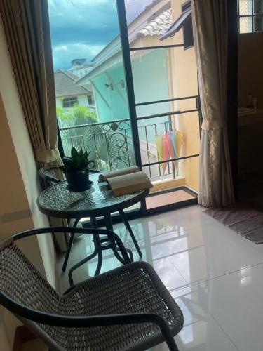 a table and a chair sitting on a balcony at Laph Kham House in Chiang Mai
