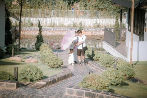 a woman and a little girl holding an umbrella at Ikigai Retreat Moc Chau in Mộc Châu