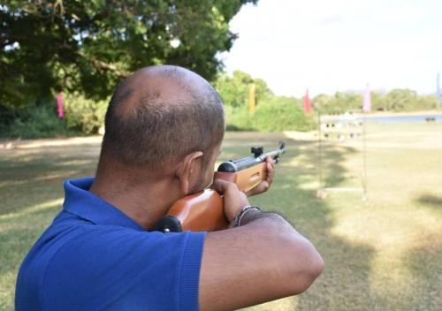 a man holding a toy gun in a field at Belihuloya Adventure Camp By Eco Team in Belihul Oya