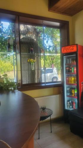 a restaurant with a table and a coke refrigerator at Guest House Lotus in Tʼelavi