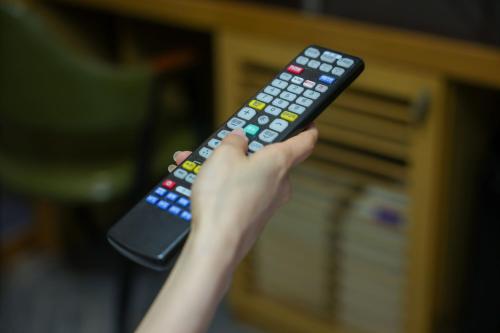 a person holding a remote control in their hand at New Day Hotel Gangnam in Seoul
