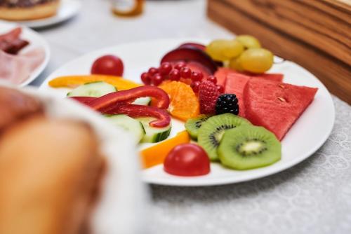a plate of fruit and vegetables on a table at Hotel Fischer am See in Heiterwang