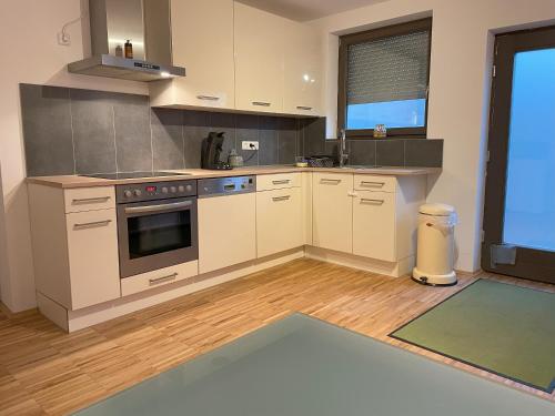 a kitchen with white cabinets and a stove at Appartement Kirschblüte in Seehof