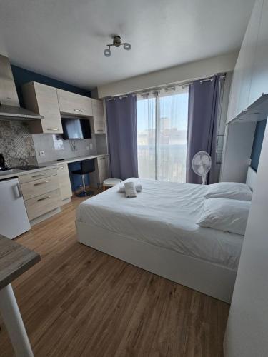 une chambre avec un grand lit et une grande fenêtre dans l'établissement Studio Grammont 3, à Tours