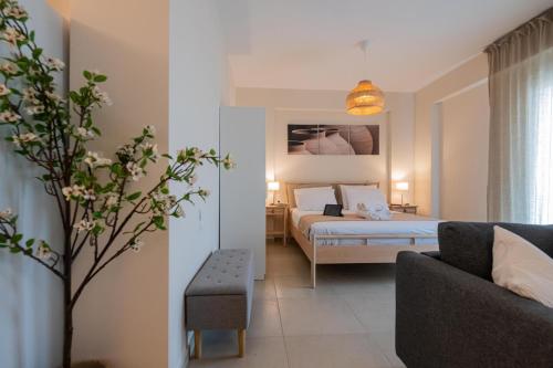 a hotel room with a bed and a couch at HomEasy Apartments - Kalamata Central Getaways with Private Parking in Kalamata
