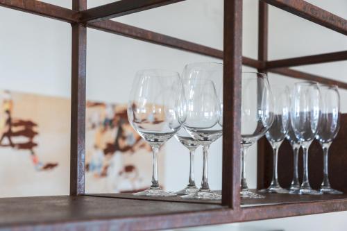 a row of wine glasses on a shelf at Casa sulle Langhe - Luxury Pool, Sauna and Jacuzzi in Diano dʼAlba