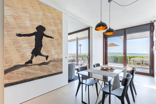 a dining room with a wall mural of a running person at Casa sulle Langhe - Luxury Pool, Sauna and Jacuzzi in Diano dʼAlba