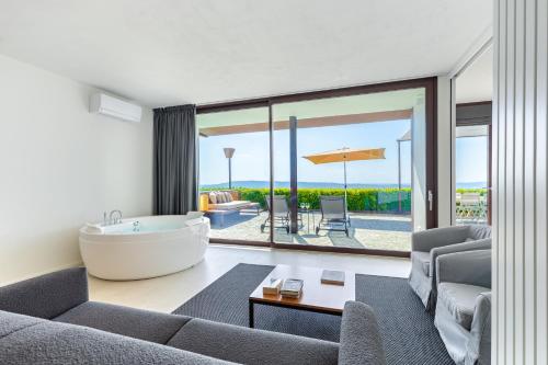 a living room with a bath tub and a couch at Casa sulle Langhe - Luxury Pool, Sauna and Jacuzzi in Diano dʼAlba