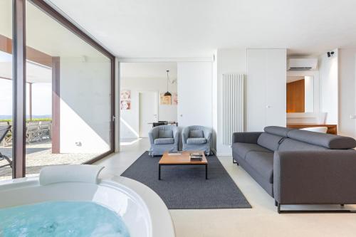 a living room with a couch and a tub at Casa sulle Langhe - Luxury Pool, Sauna and Jacuzzi in Diano dʼAlba