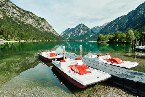 two boats are docked at a dock on a lake at Hotel Fischer am See in Heiterwang