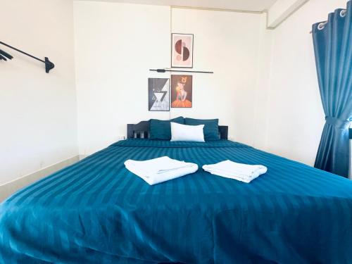a blue bed with two white towels on it at Santara Backpackers Hostel in Vang Vieng