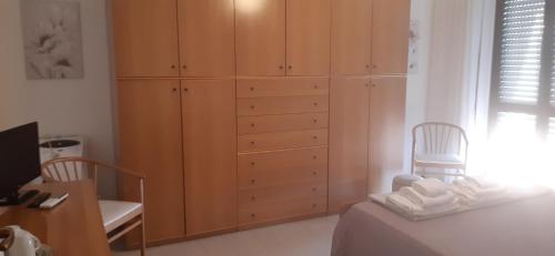 a bedroom with wooden cabinets and a bed and a desk at Villetta di Charme in Centro Città in Lanciano