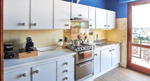 a kitchen with white cabinets and a stove top oven at Villa Vera in Verbania