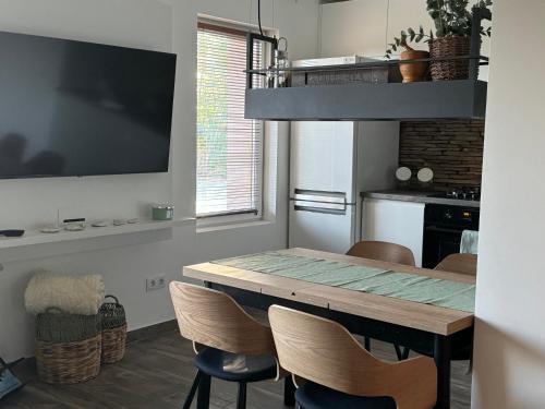 a kitchen with a dining room table with chairs at Öregvíz Vendégház in Szentendre