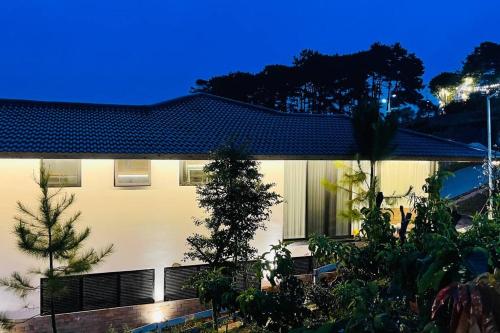 a white building with trees in front of it at Pine Villa in Tang Jran Dring