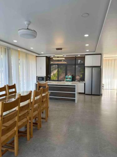 a kitchen with a table and chairs and a kitchen with a refrigerator at Pine Villa in Tang Jran Dring