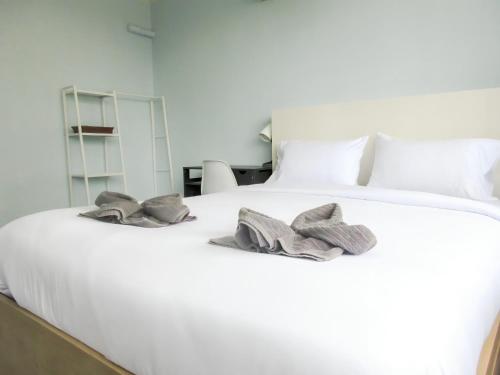 a white bed with two pillows on top of it at 420 Hostel - Ekkamai Buds & Beds in Bangkok