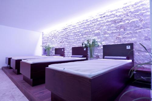 a room with three beds and a brick wall at Revital Resort Aspach in Aspach