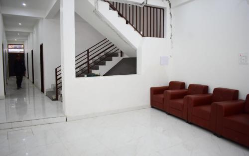 a living room with a red couch and stairs at Hotel The Yamuna by StayApart in Kharsālī