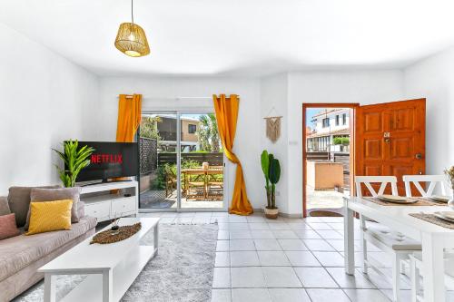 a living room with a couch and a table at Charming 3-Bedroom Maisonette with Pool Access at Regina Gardens, 700 m Venus Beach in Paphos