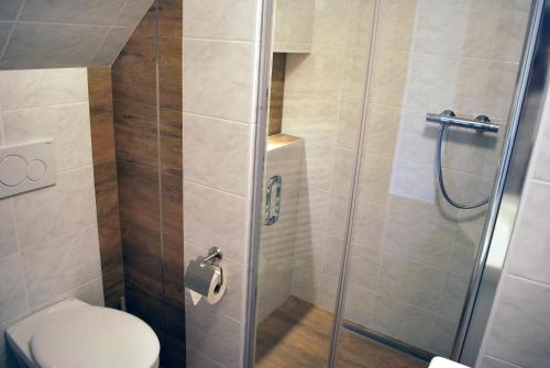 a bathroom with a toilet and a glass shower at Gästehaus Brangshof in Willich