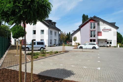 a parking lot in front of a white building at Gästehaus Brangshof in Willich