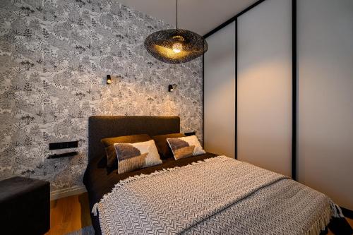 a bedroom with a bed and a wall at Liepaja Apartments Parkside in Liepāja