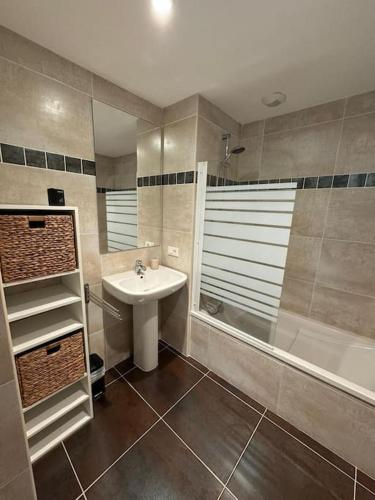 une salle de bain avec un lavabo, une douche et une baignoire dans l'établissement Suberbe appartement climatisé avec terrasse, à Saint-Raphaël