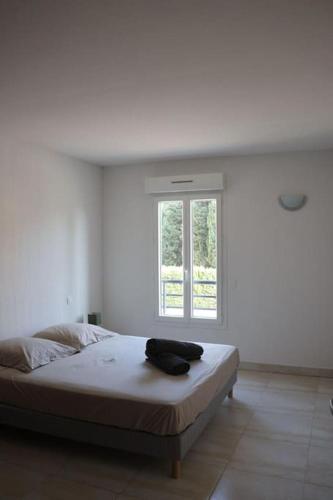 un lit dans une chambre blanche avec une fenêtre dans l'établissement Suberbe appartement climatisé avec terrasse, à Saint-Raphaël
