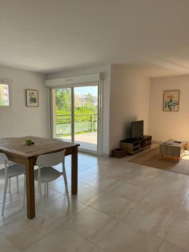 un salon avec une table en bois et une télévision dans l'établissement Suberbe appartement climatisé avec terrasse, à Saint-Raphaël