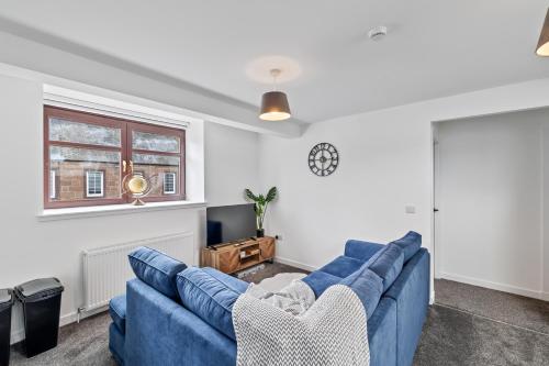 a living room with a blue couch and a tv at Prime Central Living 5-Bedroom 3-Bath Spacious House in Montrose