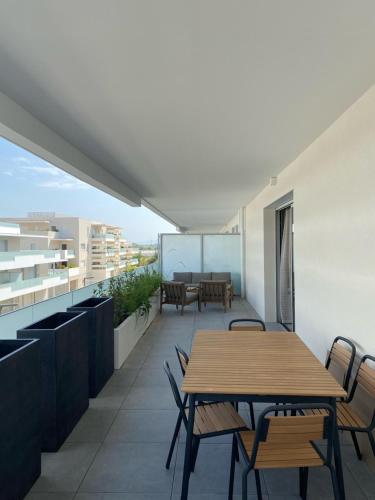 d'un balcon avec une table et des chaises en bois. dans l'établissement TRES BEL F2 NEUF, GRANDE TERRASSE, TRES BIEn SITUE, à Narbonne