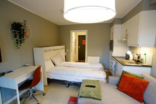 a room with two beds and a desk and a kitchen at Oppheim Holiday Apartment in Øyjordi