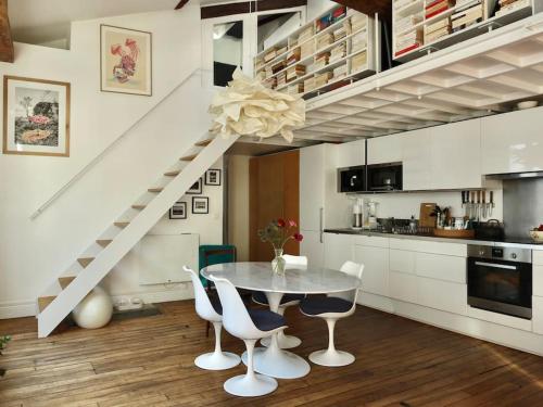 a kitchen with a table and chairs and a staircase at Loft style condo 4 people in central and trendy Paris in Paris