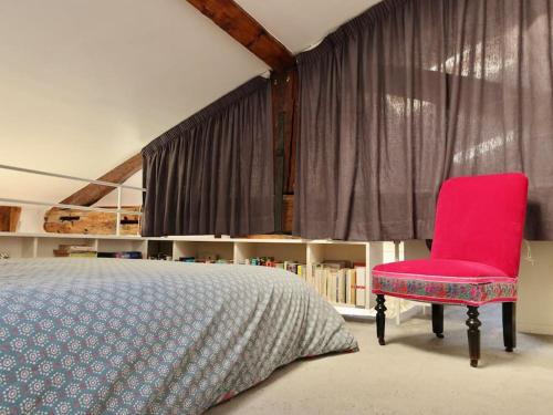 a bedroom with a bed and a red chair at Loft style condo 4 people in central and trendy Paris in Paris