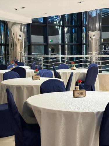 a row of tables with blue chairs and white table cloth at فندق كابيتال جيست Capital Guest hotel in Mecca