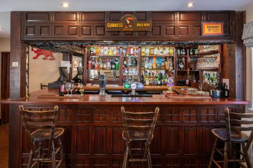a bar with three chairs at a bar at Nant Yr Odyn Country Hotel & Restaurant Ltd in Llangefni