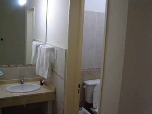 y baño con lavabo y aseo. en Apartamento Edificio Atlantis I en Villa Carlos Paz