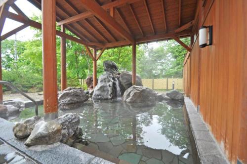 a pool of water with rocks in a building at 森のオーベルジュ 三 みつ - 旧 森厚真hotel CHUPKI - in Chitose