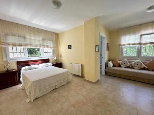 a large bedroom with a bed and a couch at Wonderful private villa near beach with sea views in Marbella