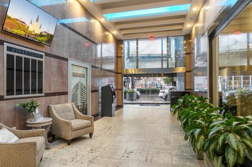 a lobby with chairs and plants in a building at Charming California Condos - Near it All in New Orleans