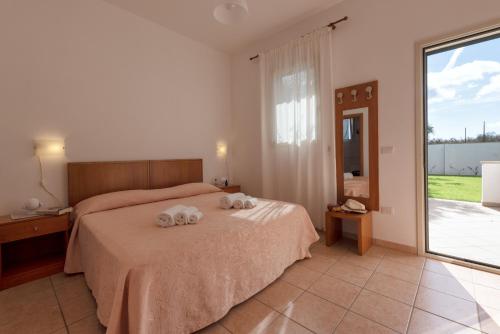 a bedroom with a bed with two towels on it at Agriturismo Panacea in Santa Cesarea Terme