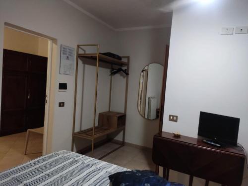 a bedroom with a bed and a mirror and a dresser at Hotel Signorini in Castiglioncello